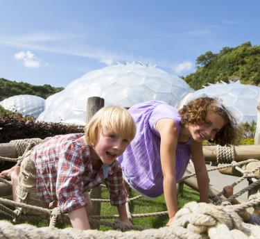 Boy and girl playing on climbing frame at Eden Project